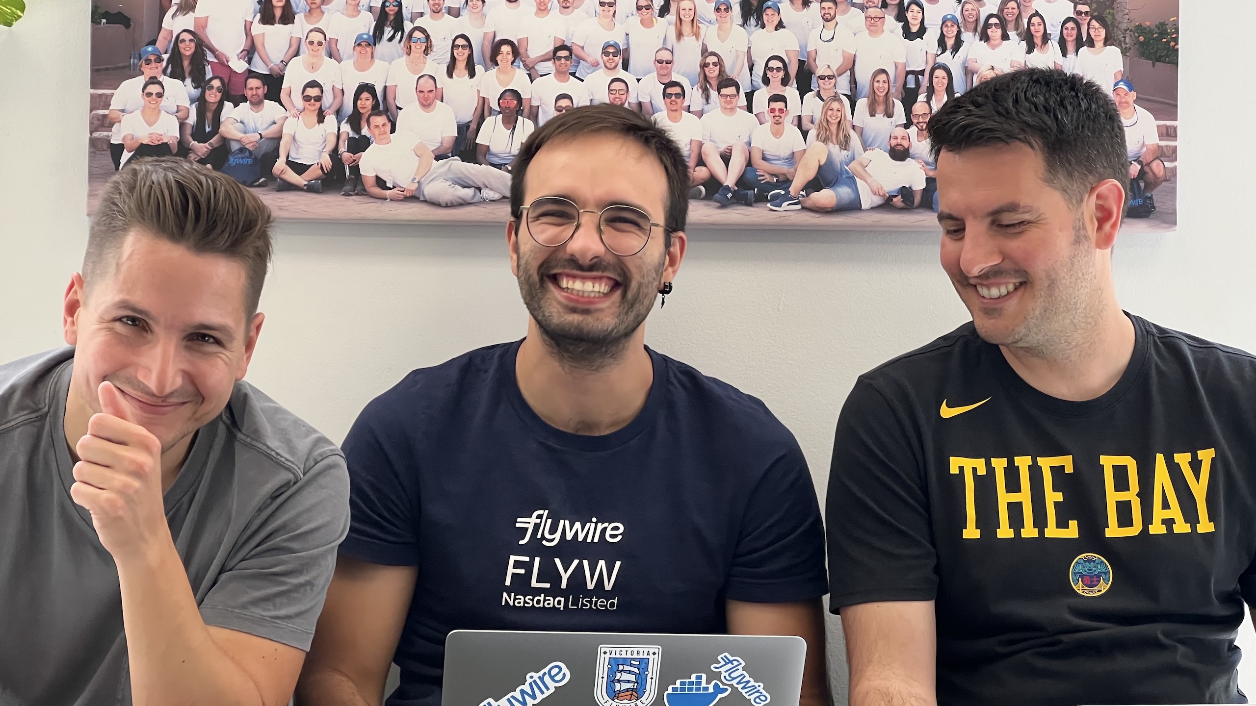 Three members of Flywire’s team smile for a photo. 