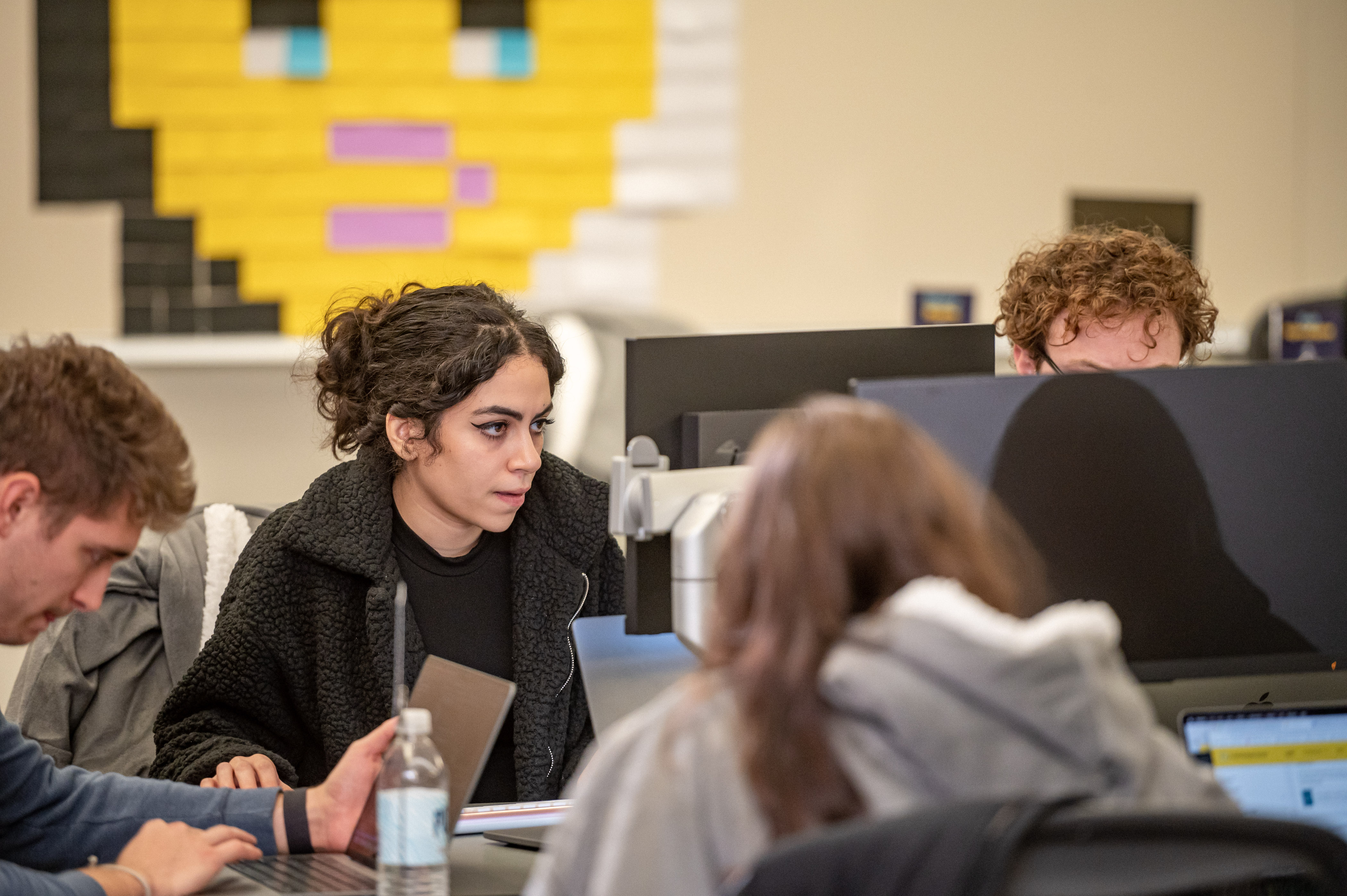 Close-up photo of one group at hackathon working intently.
