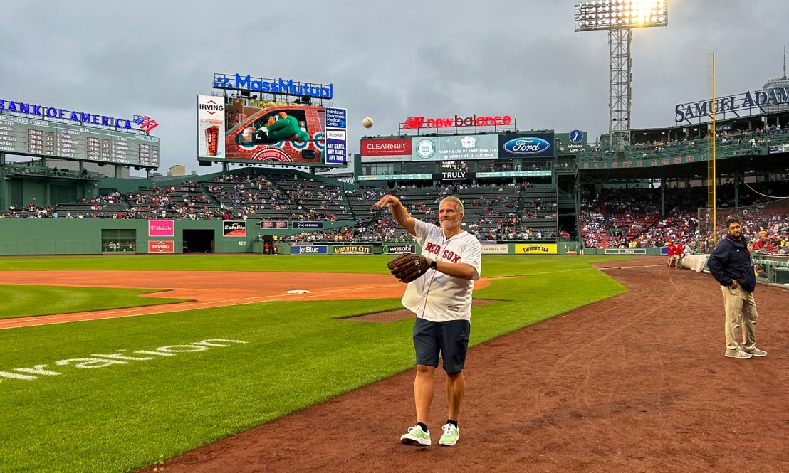 Michael Welts throwing a baseball on the field at Fenway Park.
