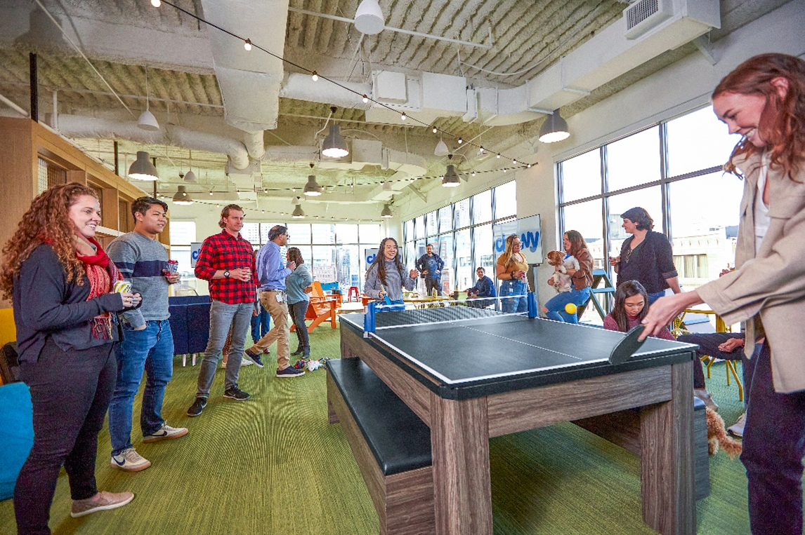 Chewy’s renovated office features a foosball and ping pong table in an indoor dog park area. | Photo: Chewy