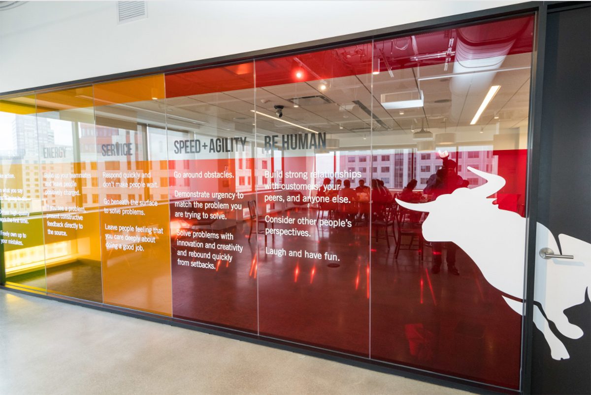 Multicolor glass wall in Bullhorn office with company values printed on it