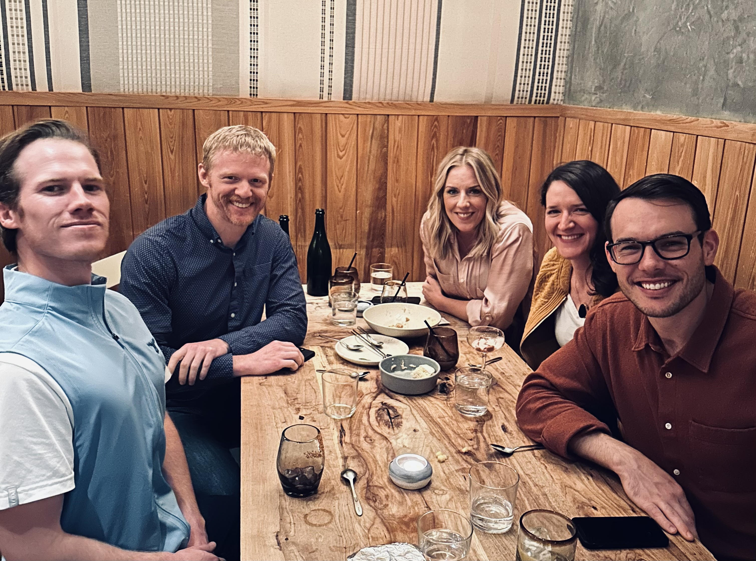 Christine Nolan and her team posing for a photo around a table.