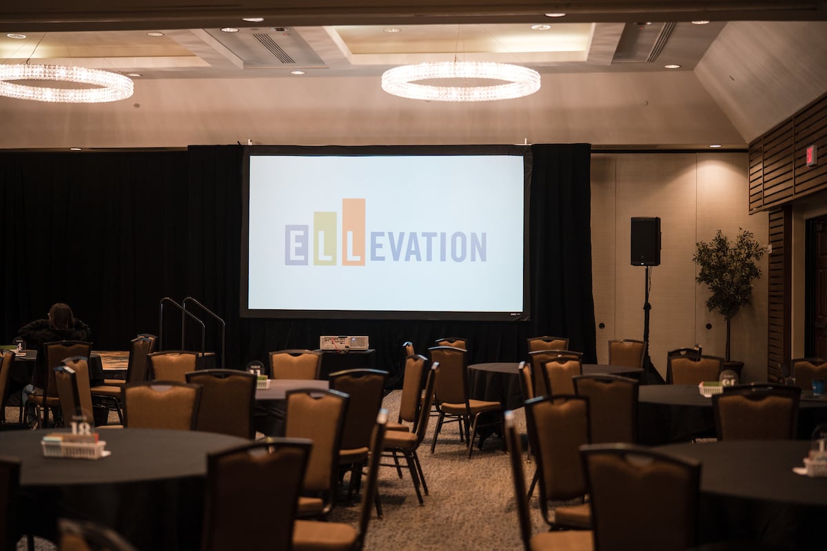 Empty ballroom with screen at back that has Ellevation Education logo