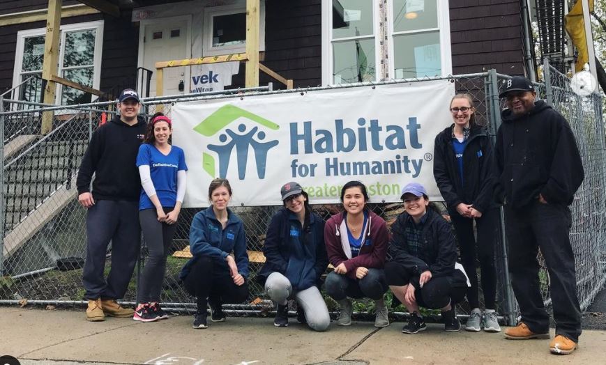 Definitive Healthcare team stands in front of a Habitat for Humanity sign