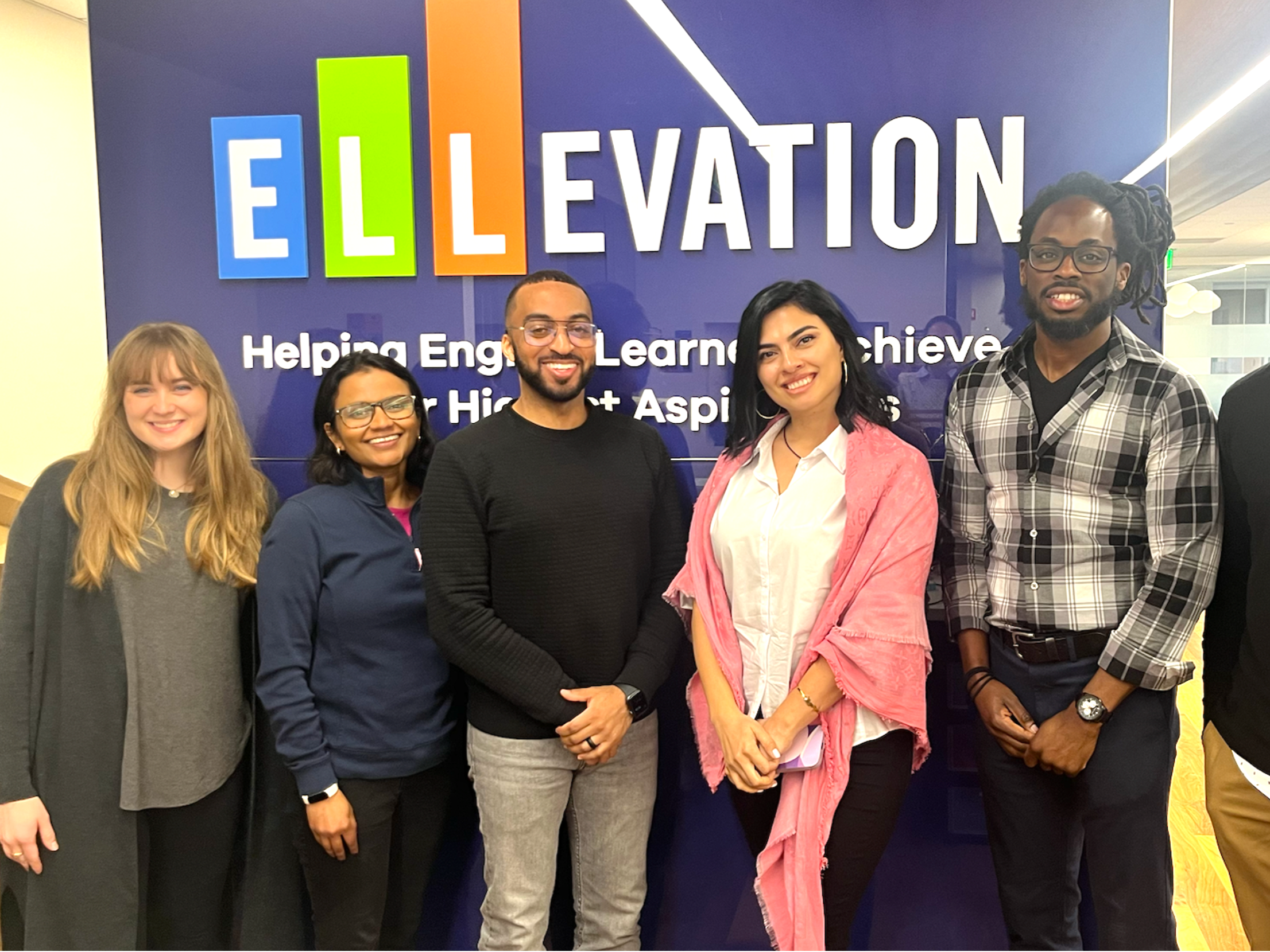 Ellevation Education team members posing for group photo in front of company logo