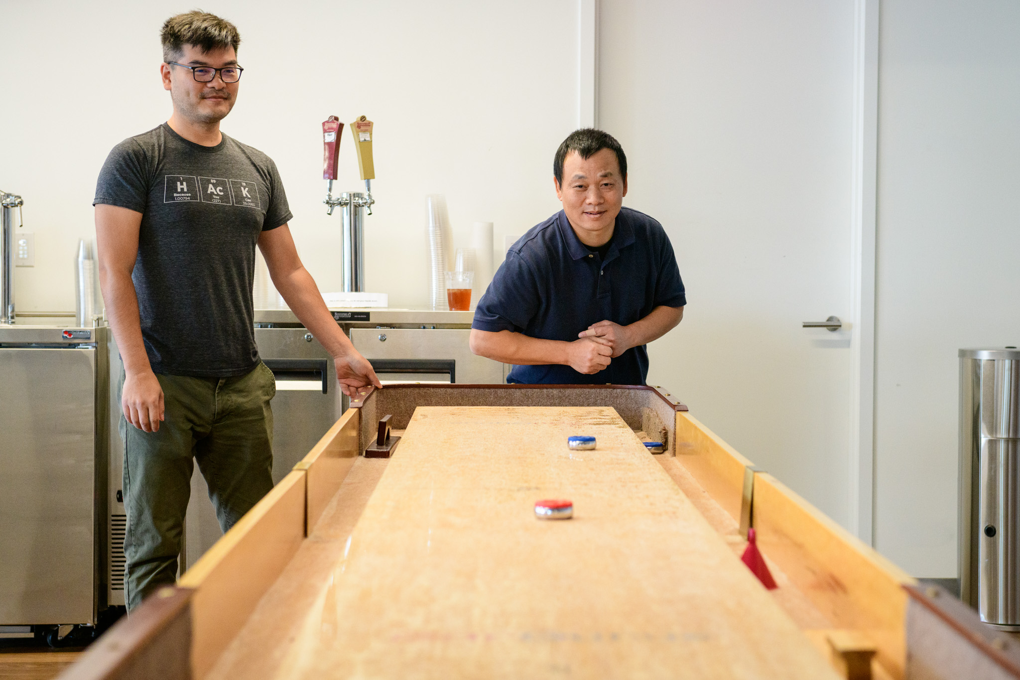 Two CarGurus employees play shuffleboard