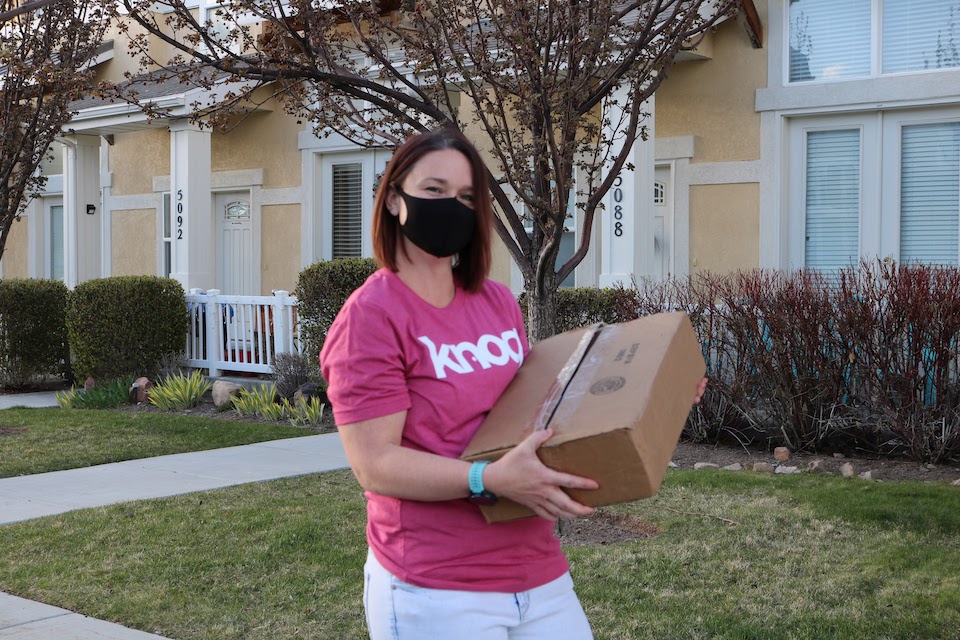 Knoq team member delivering package in COVID mask