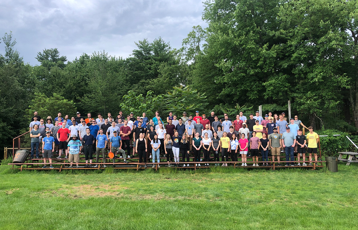 MORSE team photo outside on bleachers with trees behind them