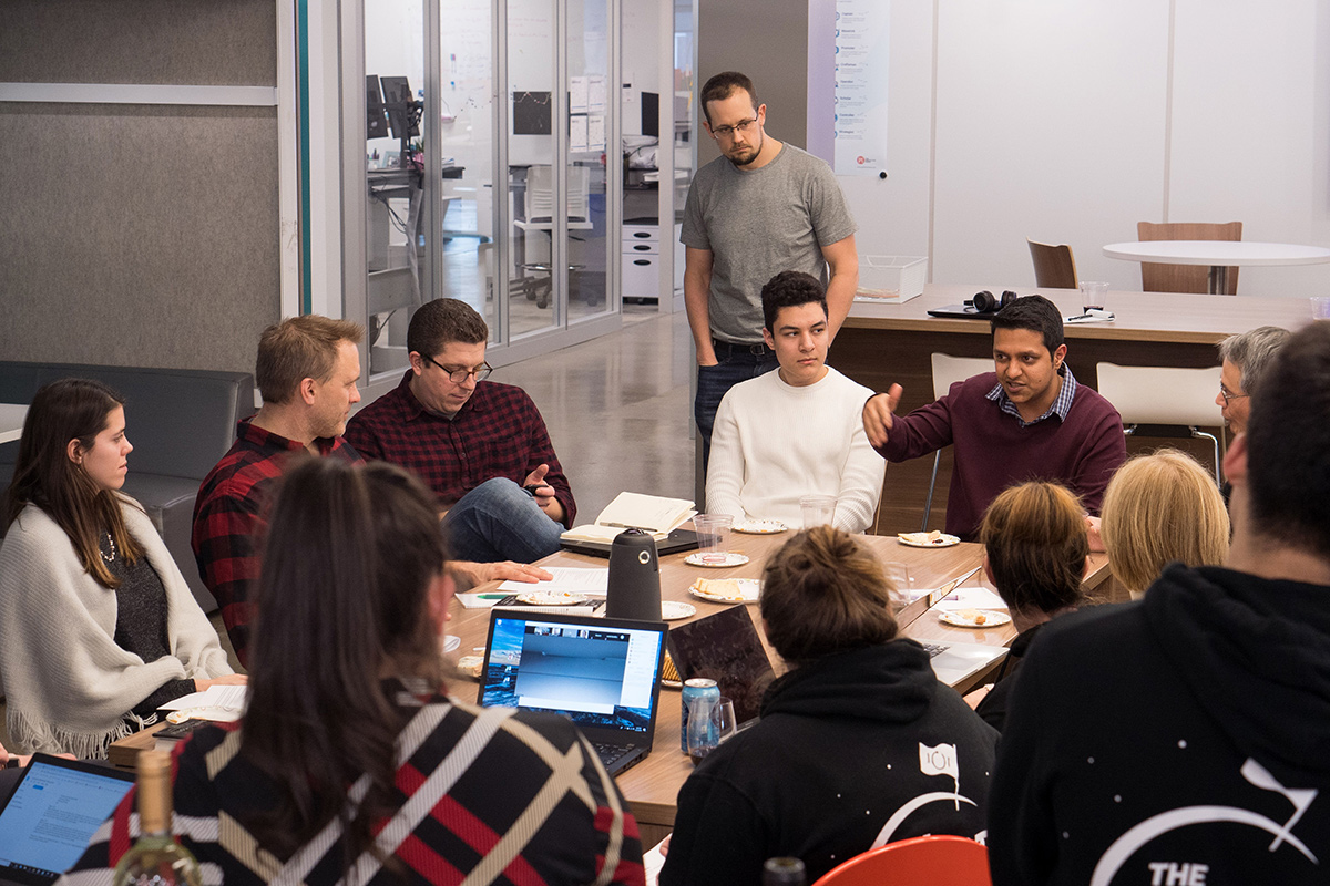 The Predictive Index coworkers having a team huddle in the office