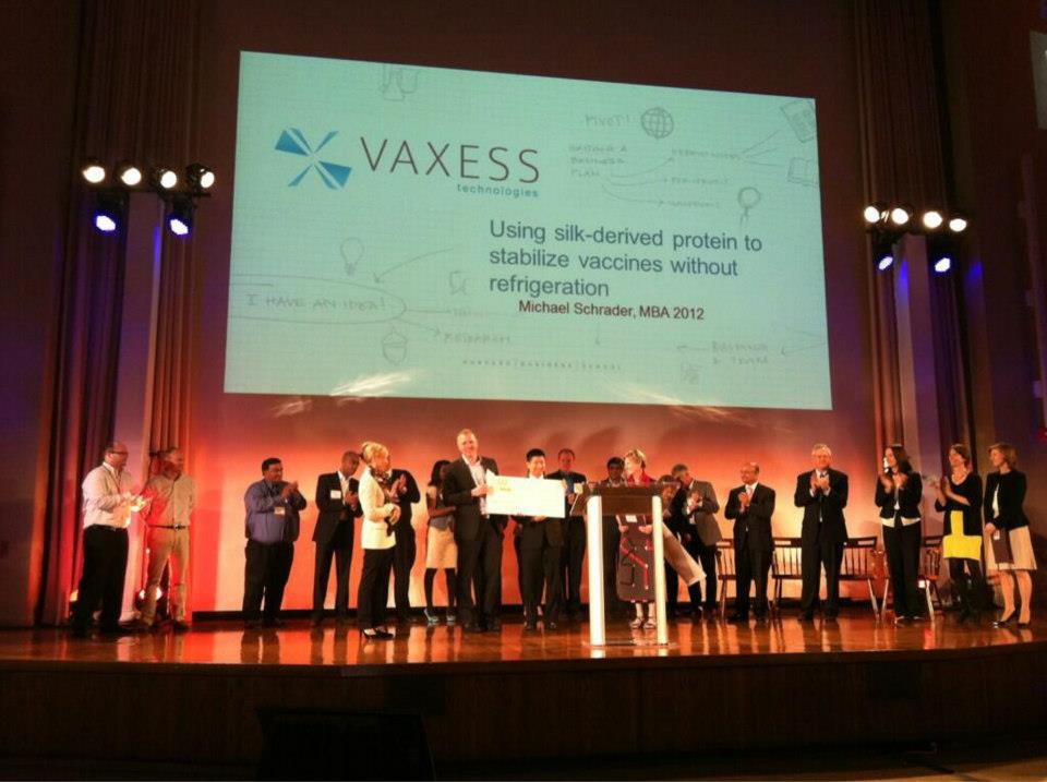 Vaxess team members on stage at an event.