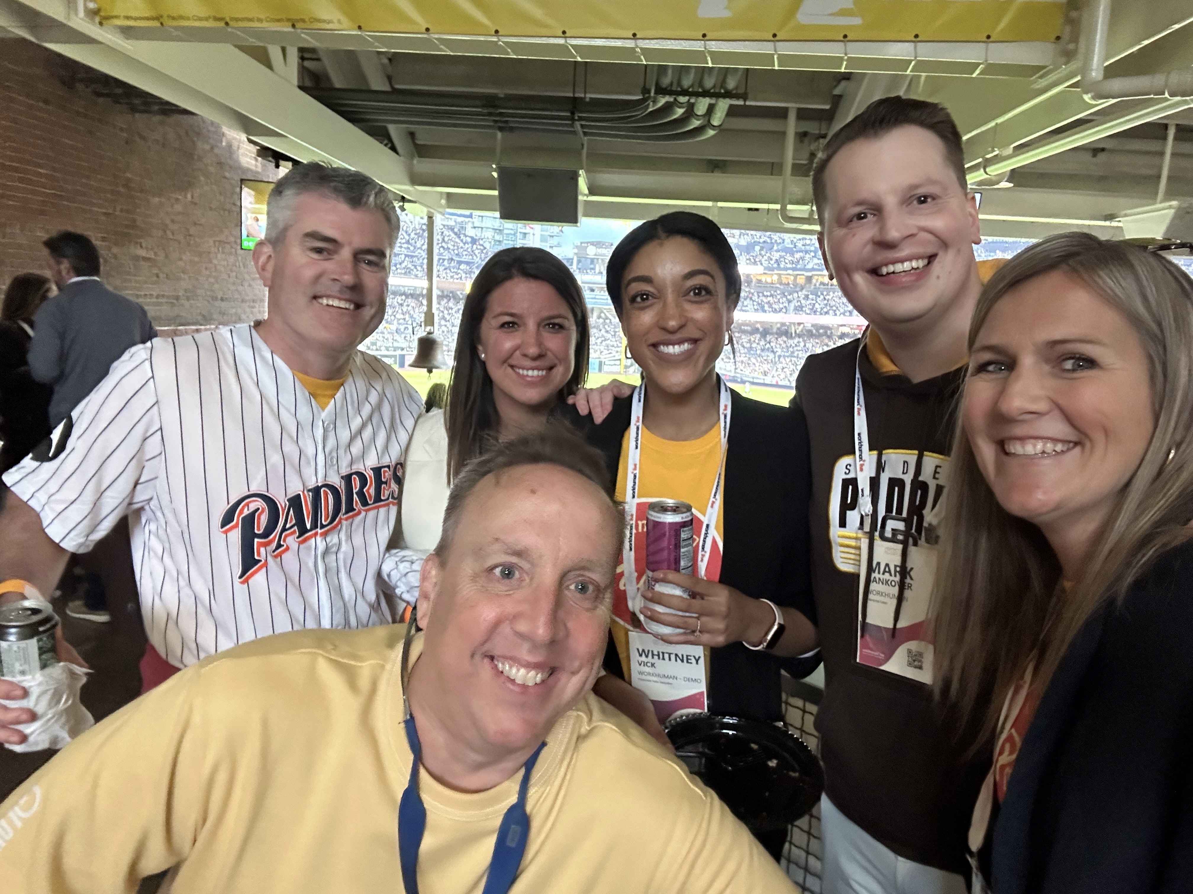 Workhuman employees pose for a group selfie at a Padres baseball game.