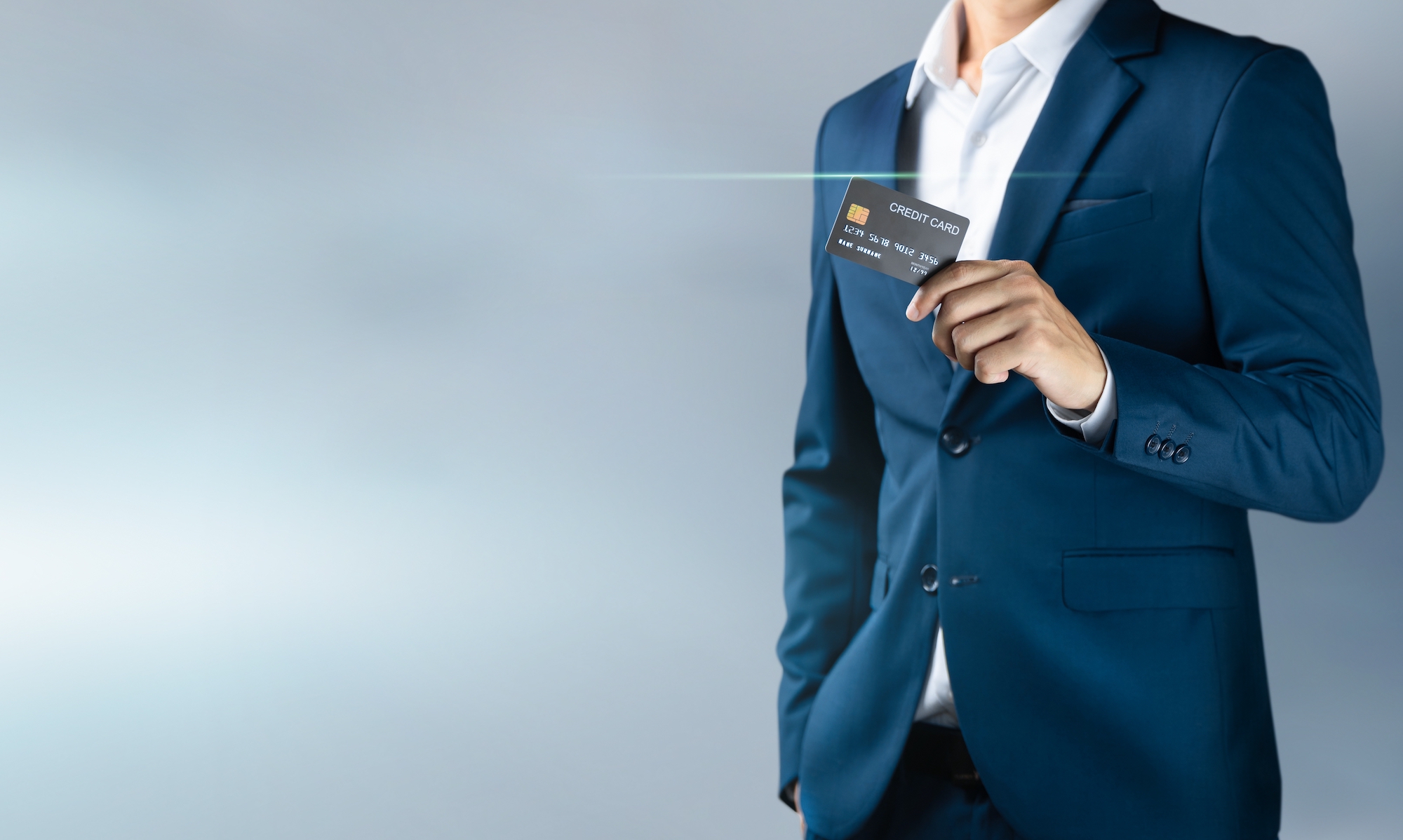 An image of a man in a suite holding a credit card is shown.