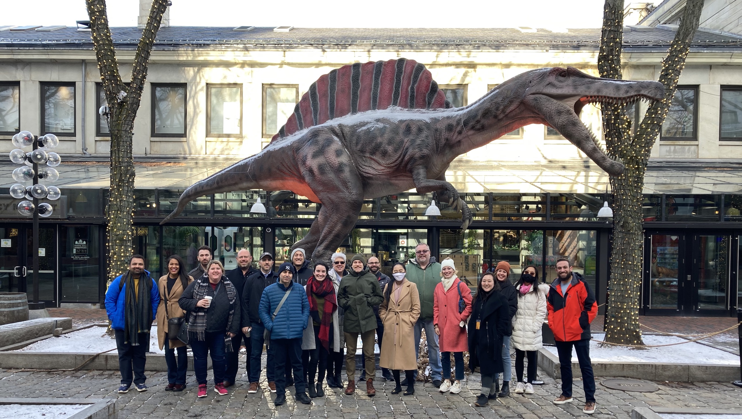 The NuvoAir team poses in front of a dinosaur statue at Faneuil Hall.