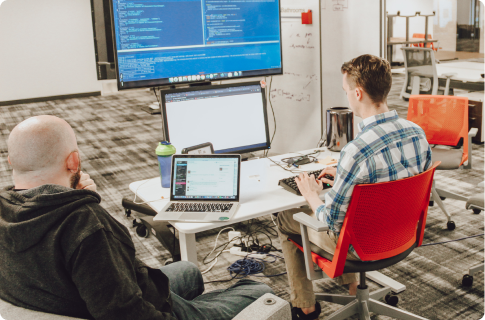 Pluralsight team members gather around a computer.