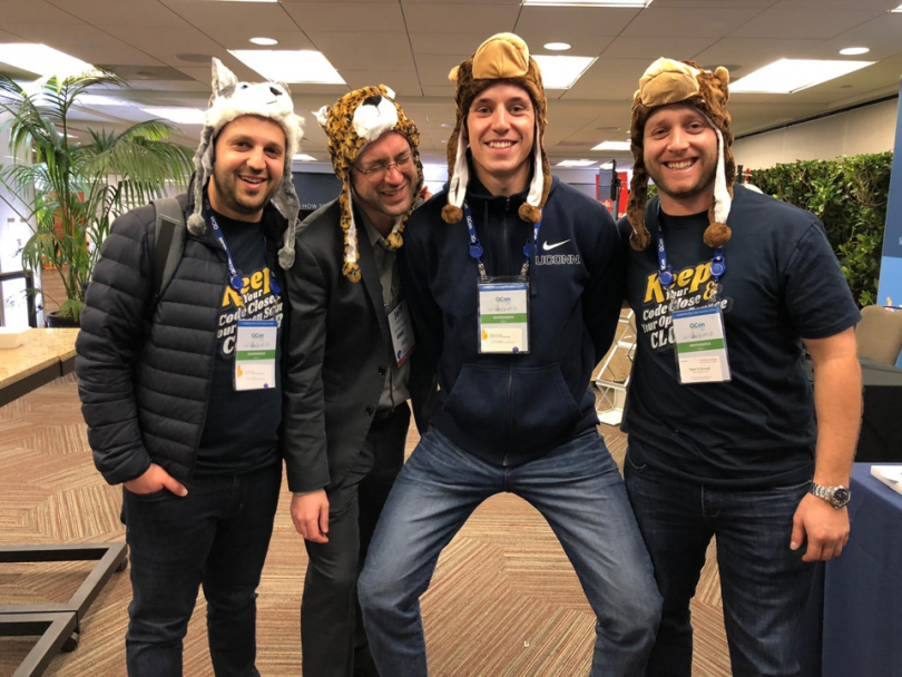 WhiteSource employees in their office, smiling and wearing hats that look like animals.