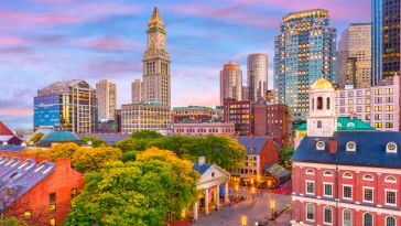 Boston skyline with Faneuil Hall and Quincy Market at dusk.