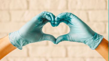 Close up of hands wearing medical gloved making a heart shape