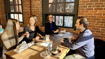 Photo of SmarterTravel coworkers eating a meal at the office.