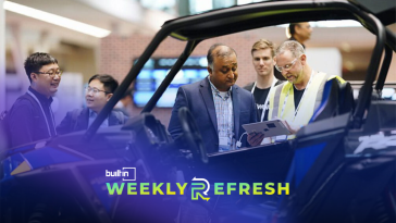 PTC employees look at a vehicle 