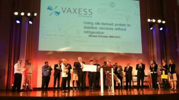 Vaxess team members on stage at an event.