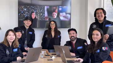 The Philo design team clusters in a conference room with Sandy Micone at the center