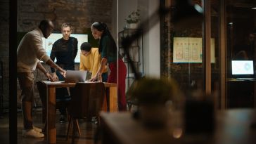 creative team collaborating in a glass conference room in a loft