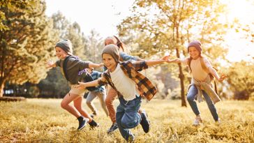 Happy children running outside are pictured.
