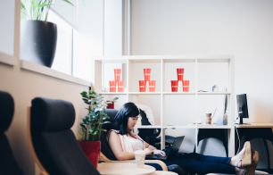An employee working from a comfy chair in the BookBub office.