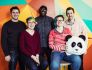 Wistia team members pose in front of a colorful wall with a panda bear head